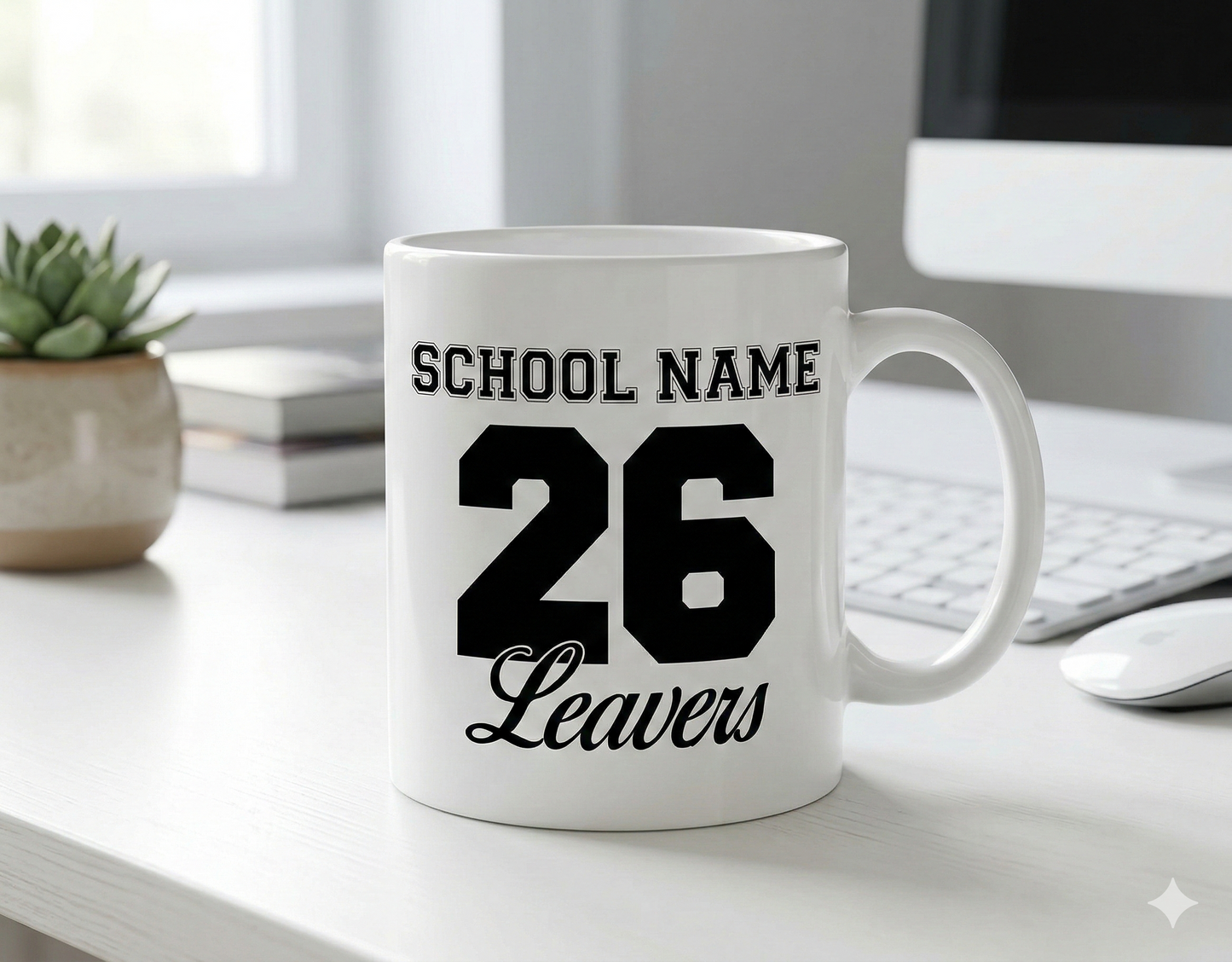 White mug with 'School Name 26 Leavers' printed on it, placed on a desk.